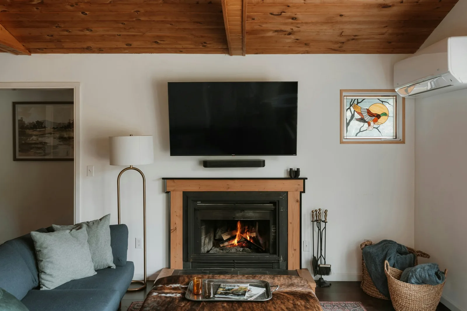 Wall-mounted television above a fireplace in a warm living room